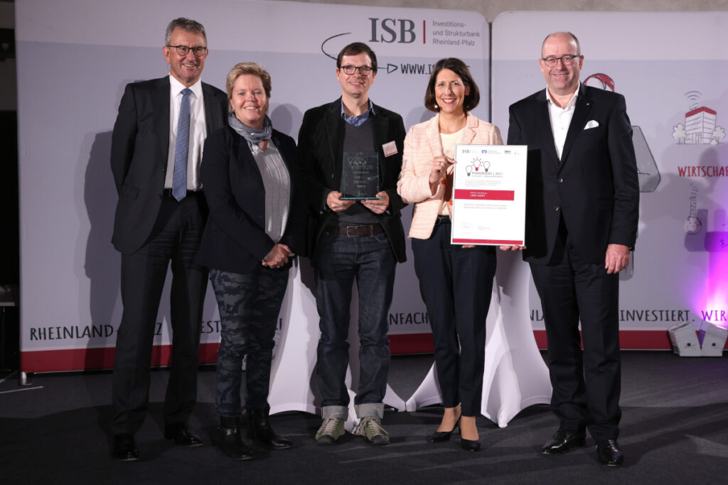 Gruppenbild bei der Verleihung des Pioniergeist Gründer-Preises. Von links nach rechts: Ulrich Dexheimer (Sprecher des Vorstandes der Investitions- und Strukturbank Rheinland-Pfalz), Dr. Simone Schelberg (SWR Landessenderdirektorin Rheinland-Pfalz), Dennis Schulmeyer (Gründer und CEO LADE GmbH), Daniela Schmitt (Wirtschaftsministerin Rheinland-Pfalz), Tobias Schmitz (Mitglied des Vorstandes der Volksbank Alzey-Worms eG).